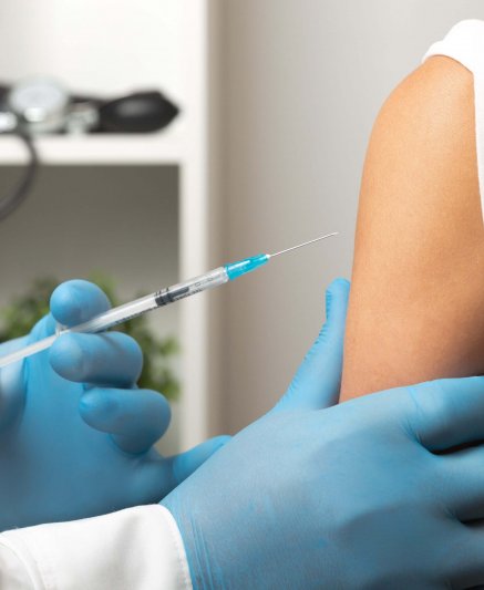 Doctor giving patient vaccine, flu shot. Doctor making a vaccination in the shoulder of patient