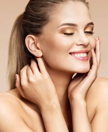 Cheerful young girl with perfect skin on beige background. Youth and Beauty